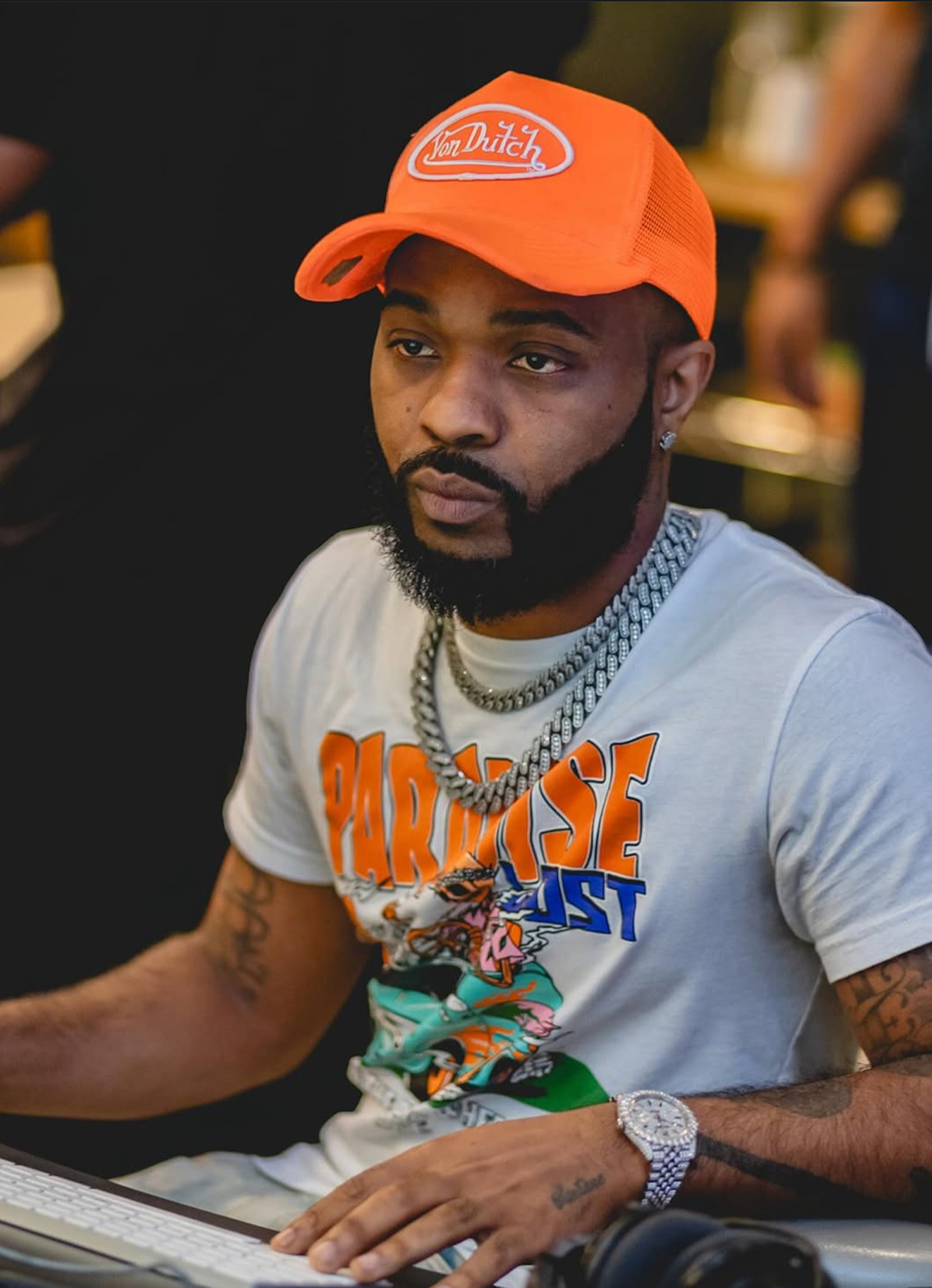 Producer at a keyboard wearing an orange hat