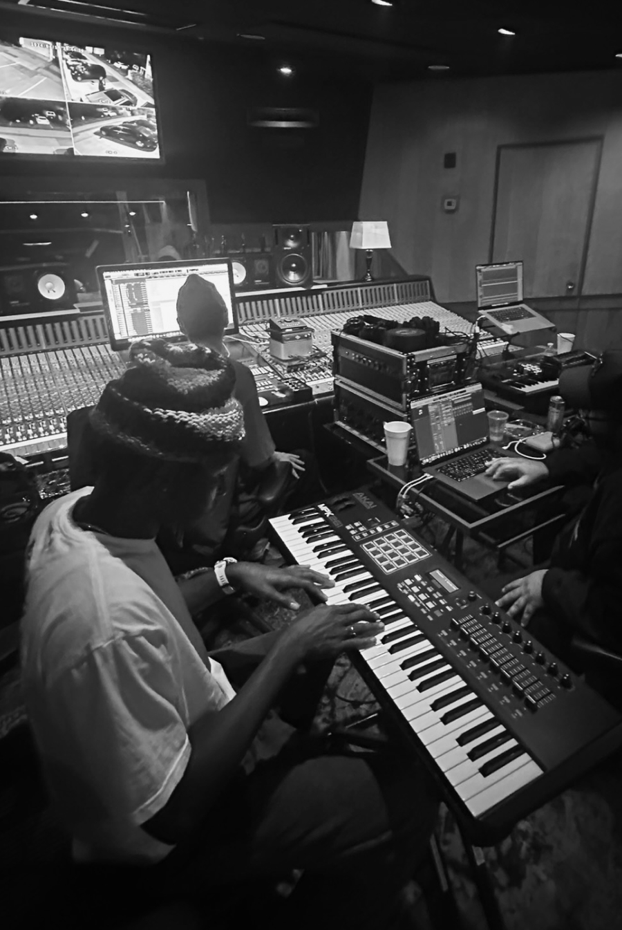 Producers working at a large mixing console and MIDI keyboard